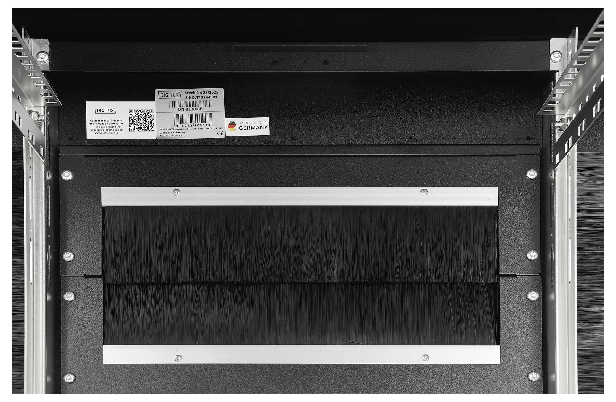 Bürstenleistenplatte, die in einem Serverrack installiert ist, mit einem Etikett mit Produktdetails und einem QR-Code.