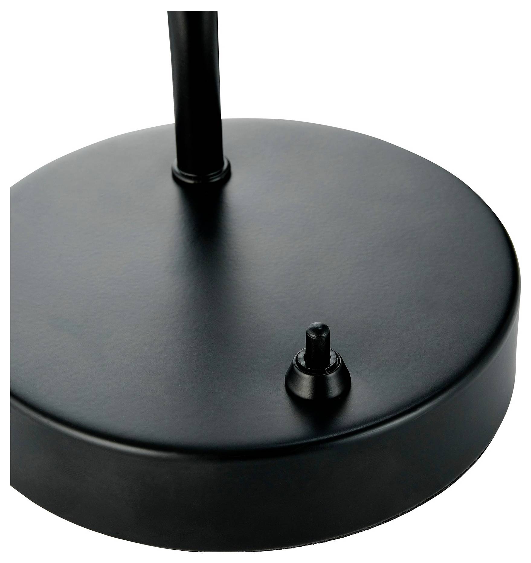 Eine Nahaufnahme einer schwarzen Metalllampenbase mit runder Form und einem kleinen zylindrischen Schalter, der aus der Oberfläche hervorragt.