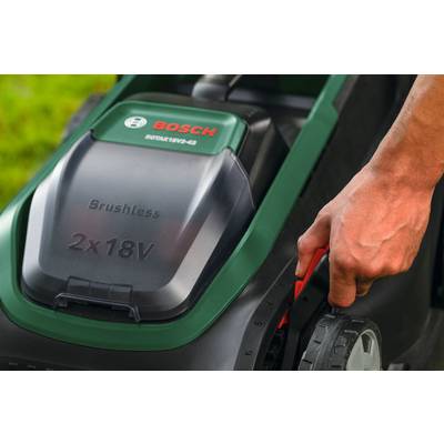 Eine Person stellt den Schubhebel zur Radhohenverstellung an einem Bosch bürstenlosen Akku-Rasenmäher mit sichtbarem „2x18V"-Merkmal auf dem Mäher ein.