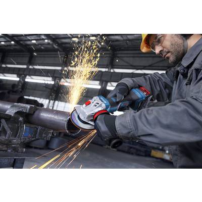 Eine Person, die einen Schutzhelm und Handschuhe trägt, benutzt einen Winkelschleifer, um Metall zu schneiden und erzeugt dabei helle Funken in einer industriellen Umgebung.