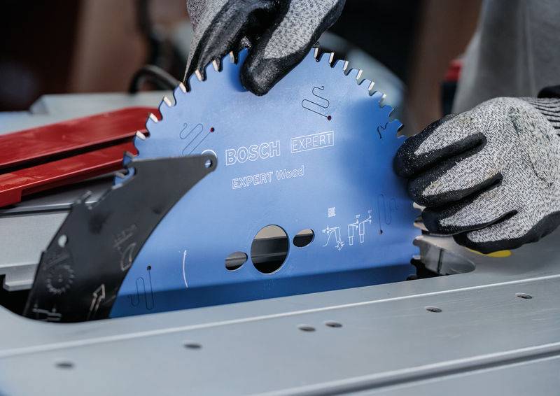 "Nahaufnahme einer Person mit Handschuhen, die ein Bosch-Sägeblatt für Kreissägen der Serie „Expert" in eine Sägenmaschine einsetzt, wobei die Produktdetails hervorgehoben werden."