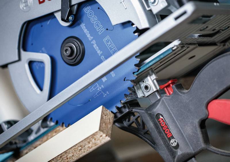 Sägeklinge schneidet Holz in einem Winkel, mit sichtbarem Bosch-Branding auf der Ausrüstung.