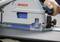 Eine Person nutzt eine Bosch Elektrosäge, um ein Stück Material durchzuschneiden, wobei Präzision und Konzentration beim Holzbearbeitungsprozess unter Beweis gestellt werden.