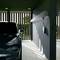 Ein schwarzes Auto steht in einer modernen Garage mit einem an der Wand montierten Elektrofahrzeug-Ladegerät, das Schatten durch Lüftungsschlitze auf den Boden wirft.