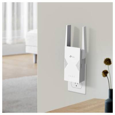 Ein weißer WLAN-Verstärker, der in eine Wandsteckdose eingesteckt ist, mit eingeschalteten Anzeigelampen in einer hellen Wohnzimmerumgebung.