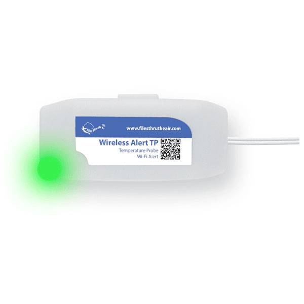 Ein weißes Gerät mit der Bezeichnung „Wireless Alert TP" mit einer grünen LED-Leuchte, die den Betriebsstatus anzeigt. Verbundene Drähte erstrecken sich von der rechten Seite.