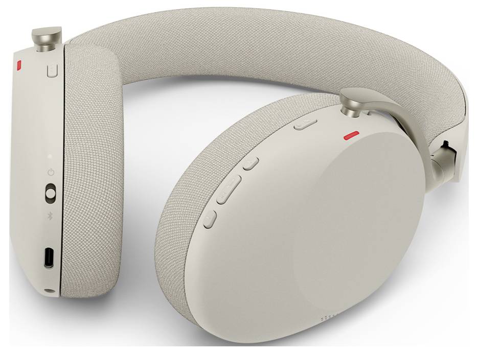 Beige kabellose Over-Ear-Kopfhörer mit stoffbezogenem Kopfbügel, Bedienelemente auf dem Ohr und rote Statusanzeigen auf weißem Hintergrund dargestellt