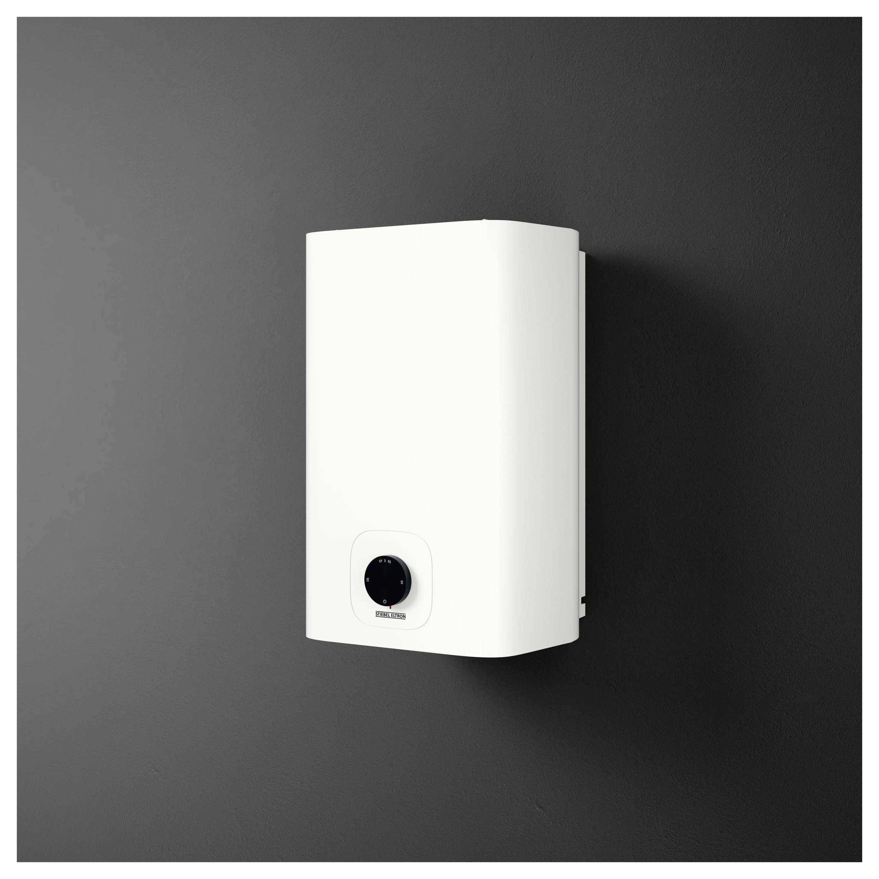 Ein weißer elektrischer Warmwasserbereiter, der an einer dunklen Wand montiert ist und über einen Bedienknopf in der unteren Mitte zur Temperatureinstellung verfügt.