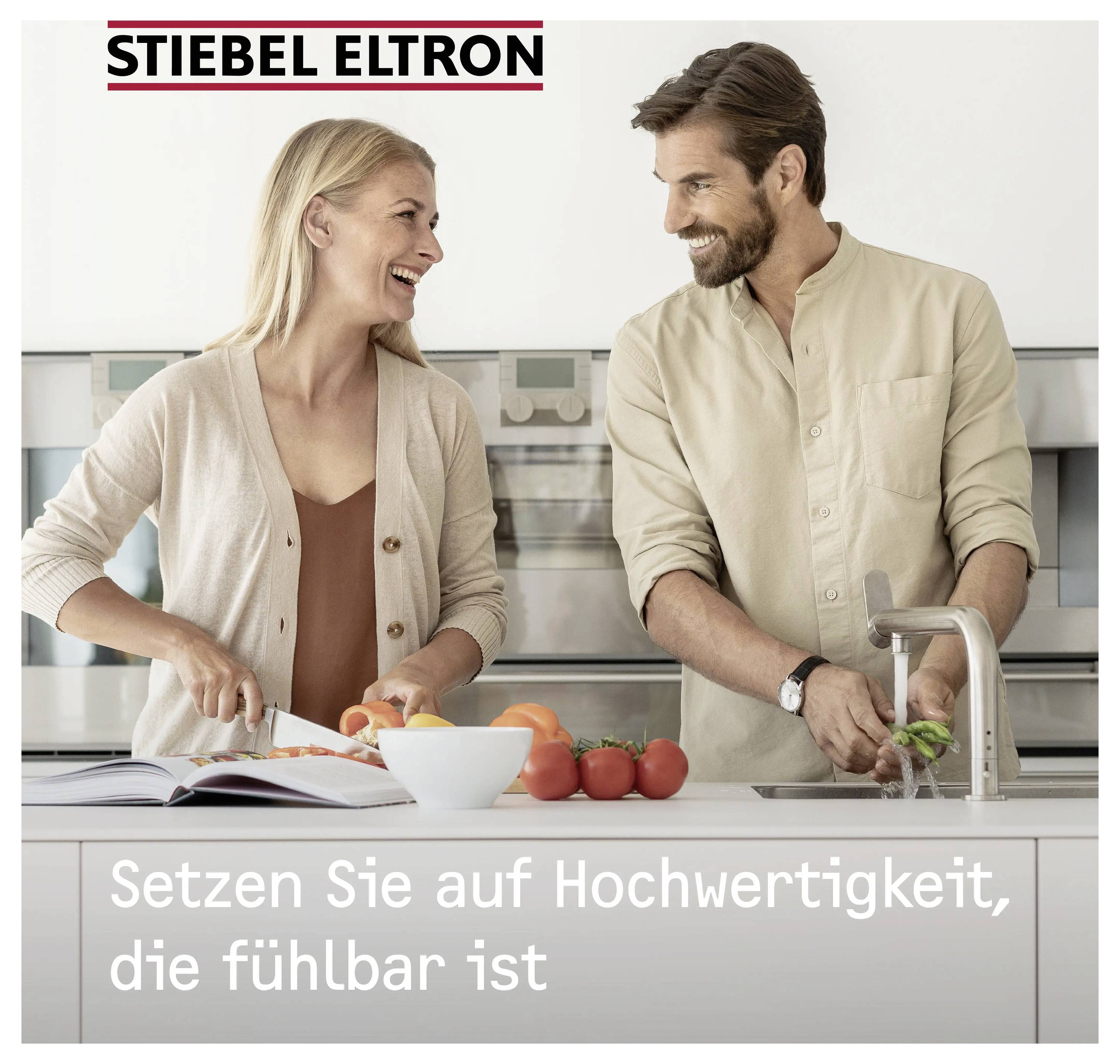Ein lächelndes Paar in einer Küche, einer schneidet Gemüse, mit dem Text „Setzen Sie auf Hochwertigkeit, die fühlbar ist" darunter.
