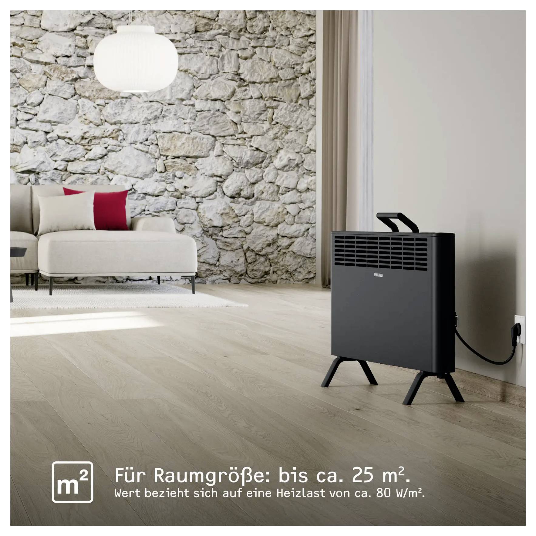 Ein Wohnzimmer mit einer Steinwand, beigem Sofa, roten Kissen und einem schwarzen Elektroheizer in der Ecke. Der Text lautet „Für Raumgröße: bis ca. 25 m²".