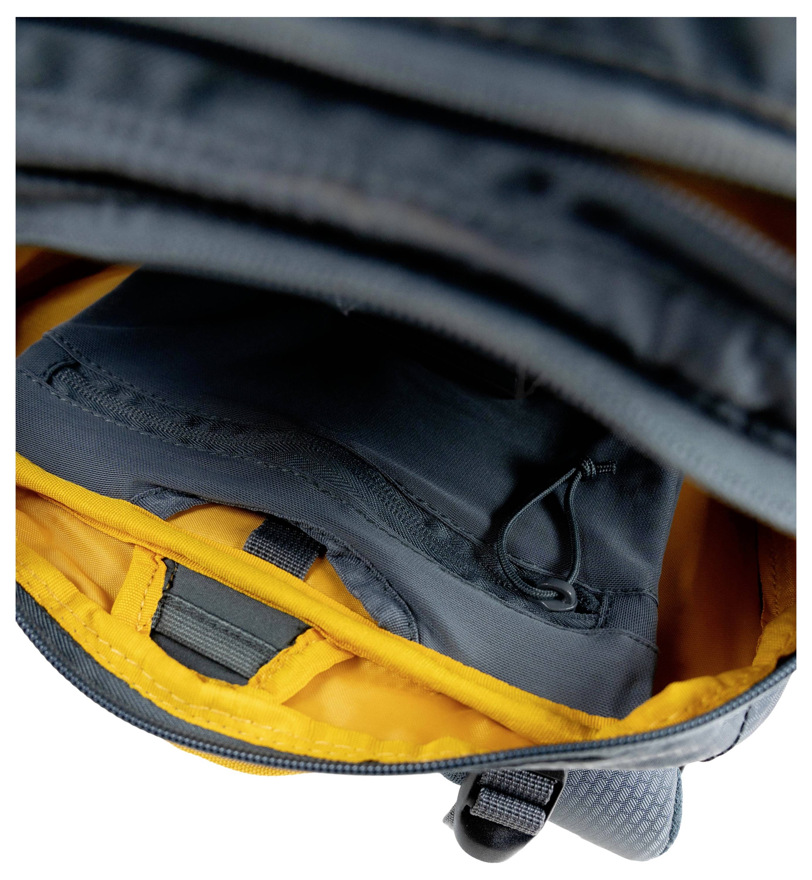 Ein grauer und gelber Rucksack von oben gezeigt mit offener Hauptkammer, die sein Innendesign und Aufbewahrungstaschen zeigt.