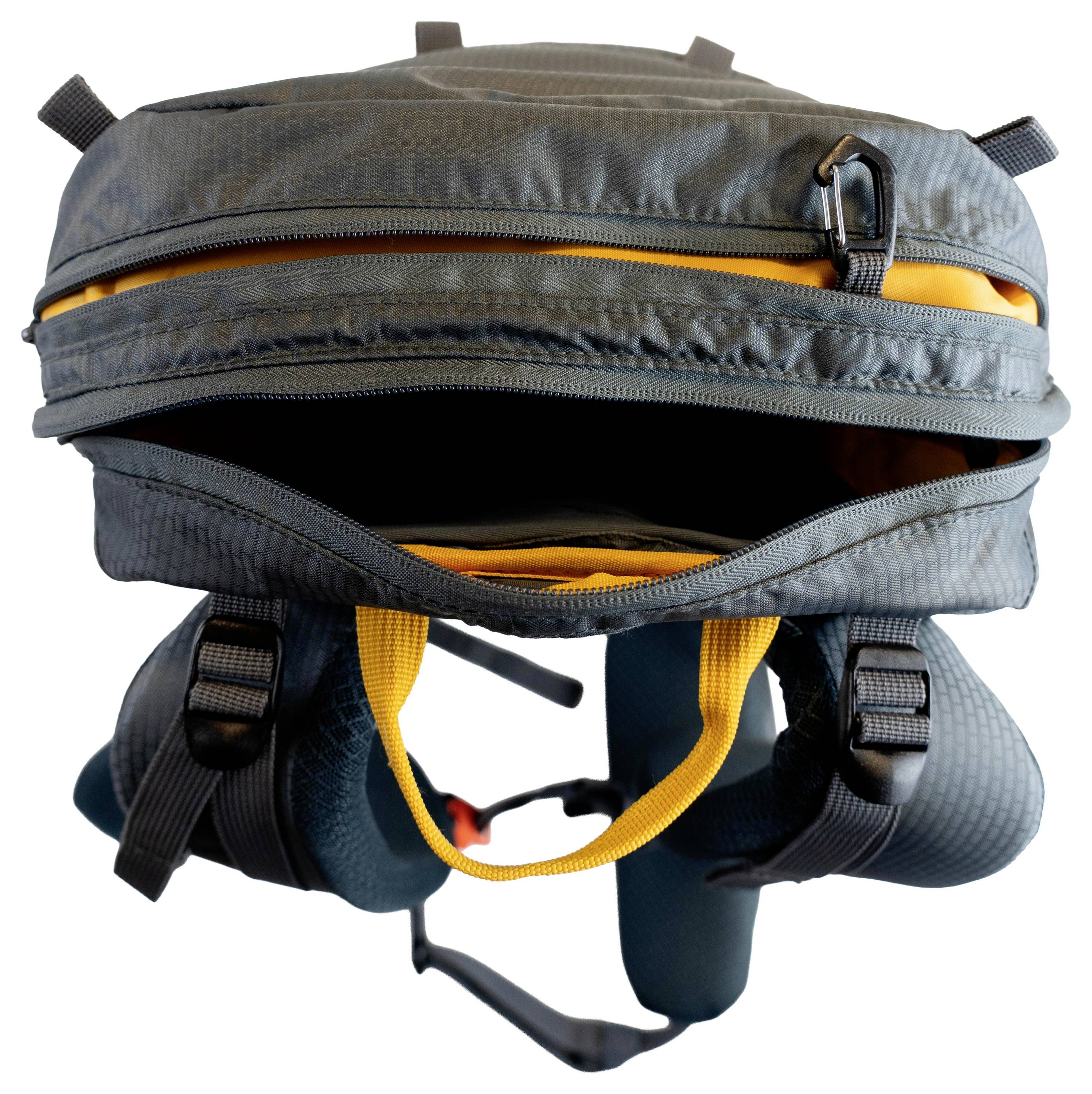 Ein grauer Rucksack mit gelbem Innenfutter ist offen und zeigt das Hauptfach. Zwei Schultergurte und Reißverschlussdetails sind sichtbar.