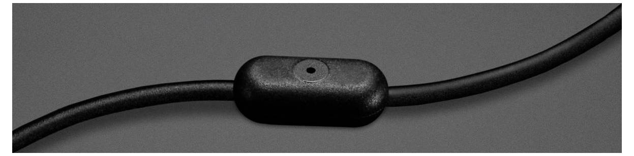 Eine Nahaufnahme eines schwarzen Inline-Mikrofons auf einem Kopfhörerkabel.