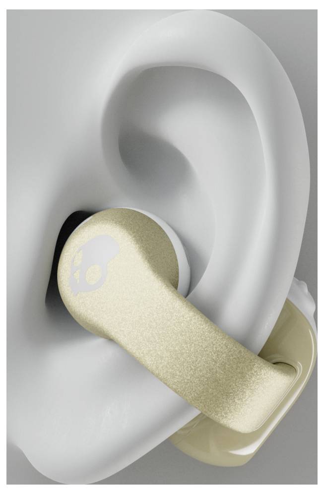 Ein Ohrhörer mit goldenem Finish und Schädellogo wird in ein menschliches Ohr eingesetzt und zeigt seine Passform und sein Design.