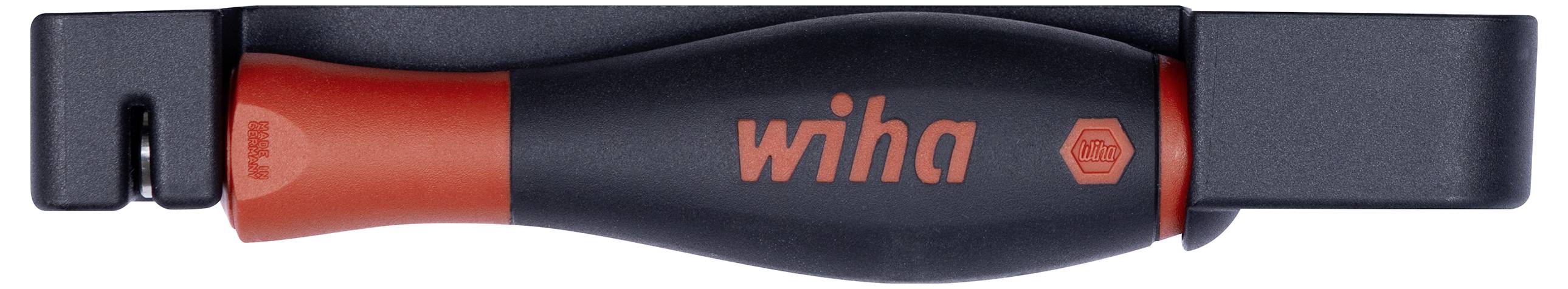 Eine Person benutzt einen Multifunktions-Schraubendreher mit rotem Griff neben verschiedenen Schraubendreher-Bits und Werkzeugen auf einer grauen Oberfläche im Freien.