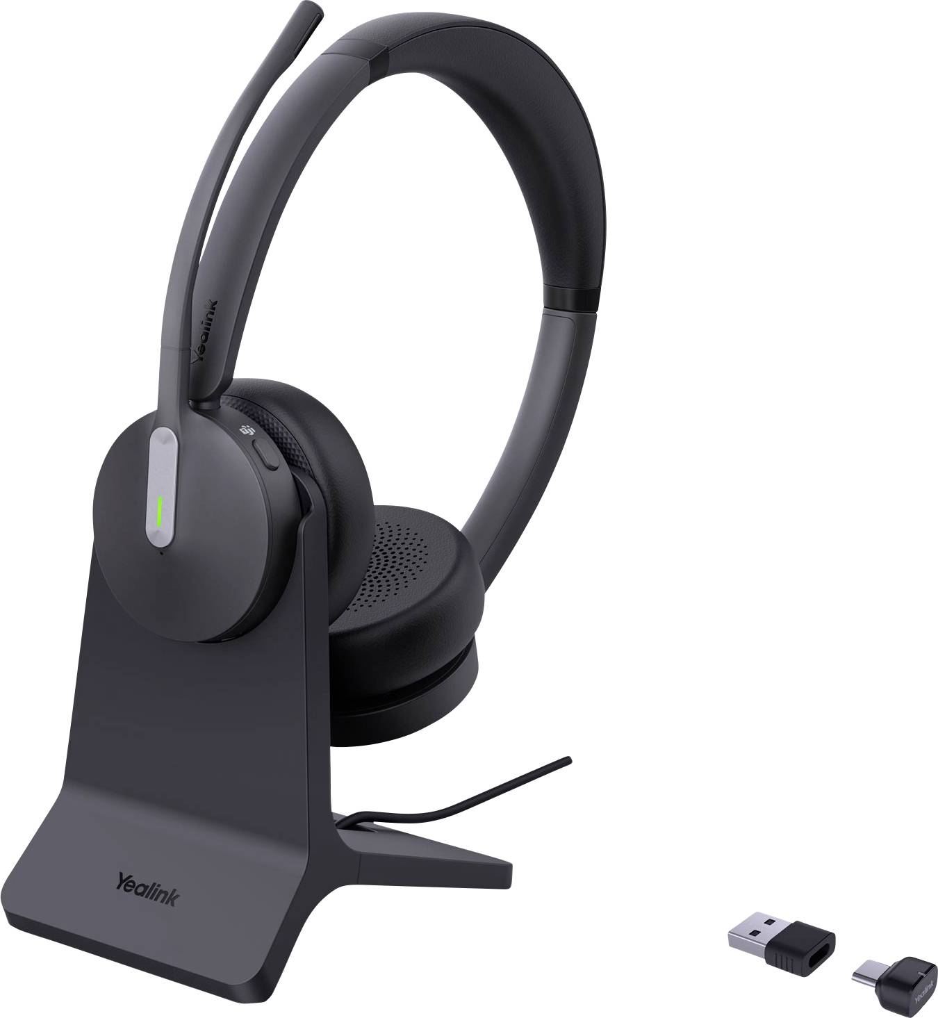 Ein schwarzes kabelloses Headset mit Mikrofon auf einer Ladestation, begleitet von einem USB-Dongle und einem Adapter auf weißem Hintergrund.