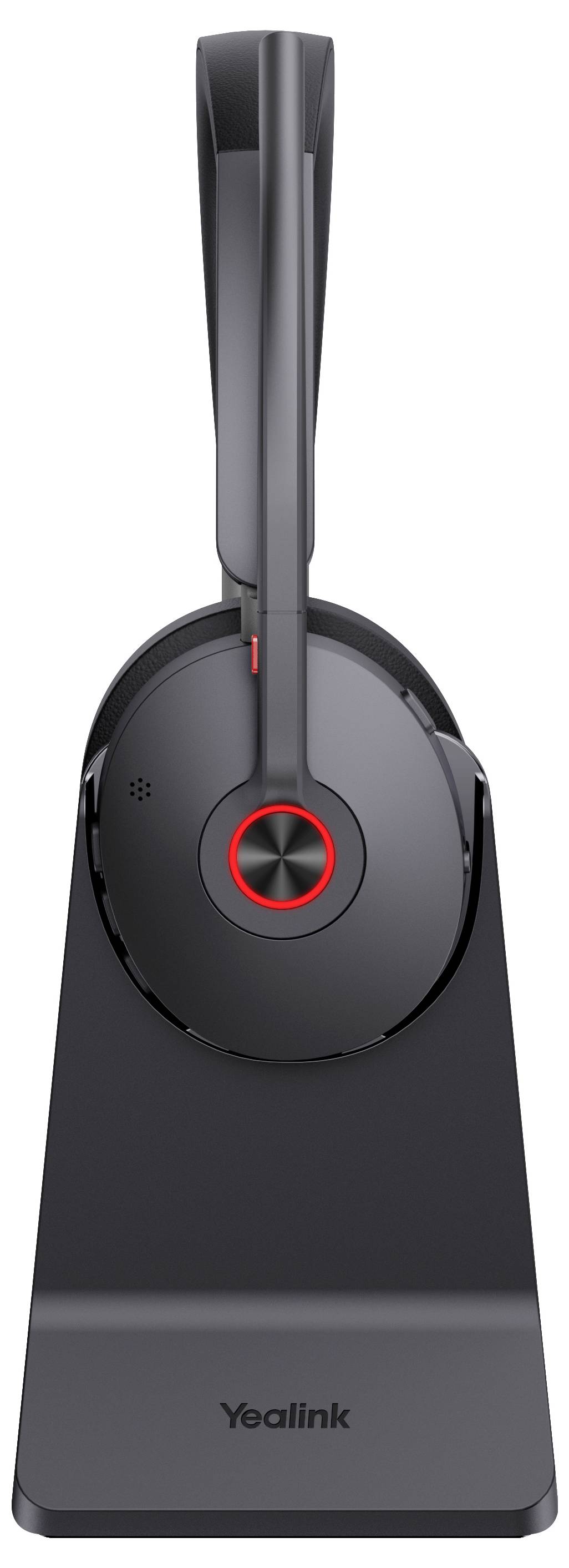 Ein elegantes, schwarzes kabelloses Headset mit gepolstertem Ohrpolster und einer Kopfbügel-Schleife ruht auf einer Ladestation, die auf der Basis "Yealink" anzeigt.