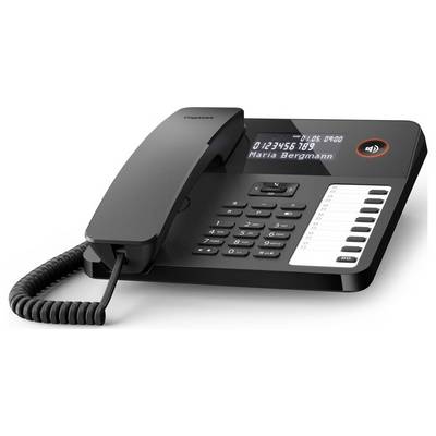 Ein schwarzes Bürotischtelefon mit digitalem Display zeigt die Ziffern '0123456789' und den Namen 'Maria Bergmann' an, daneben Zahlentasten und ein spiralförmiges Kabel.