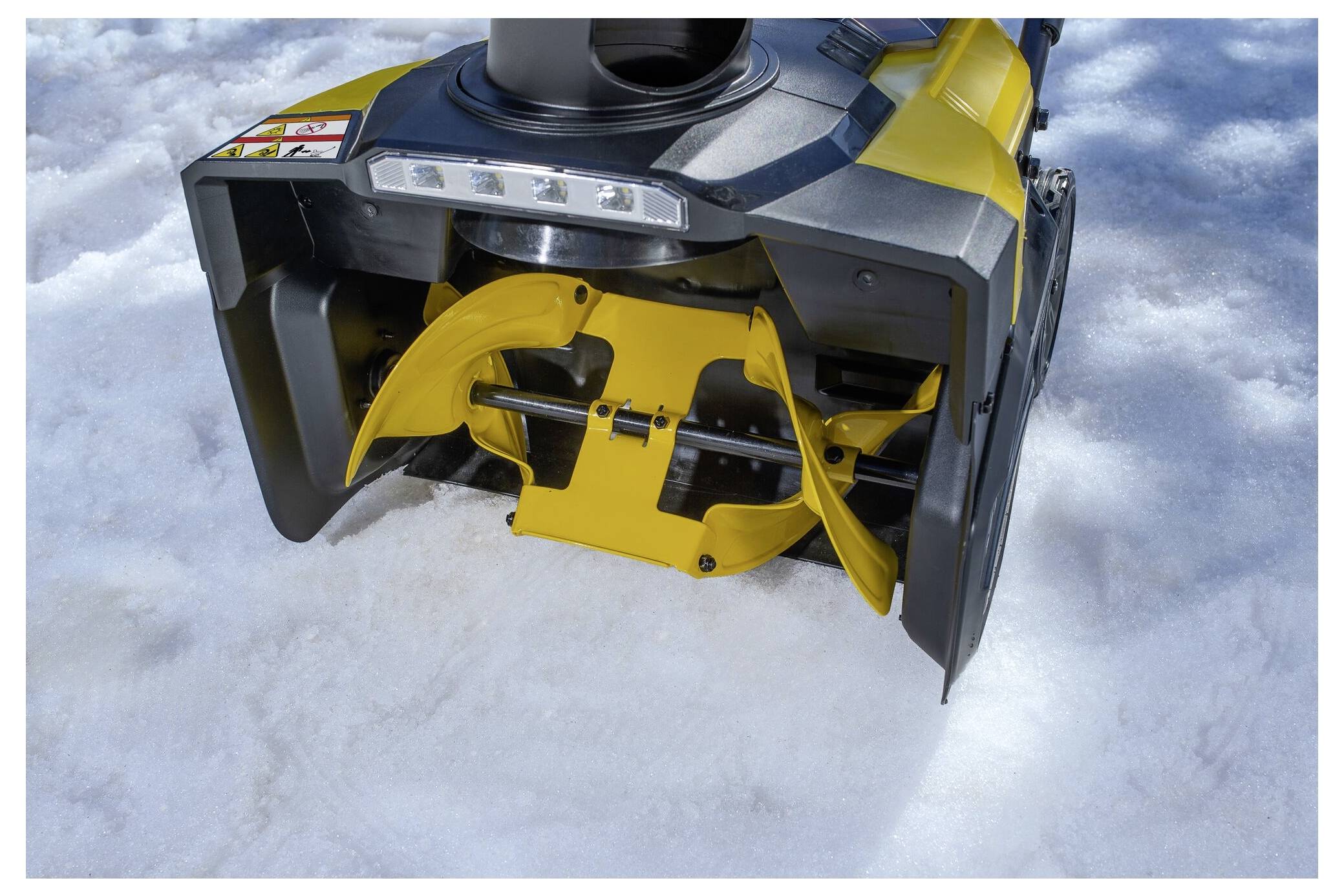"Stanley FatMax" Laubgebläse wird von einer behandschuhten Hand gehalten, wobei das Design und das Batteriefach vor einem grünen Outdoor-Hintergrund hervorgehoben werden.