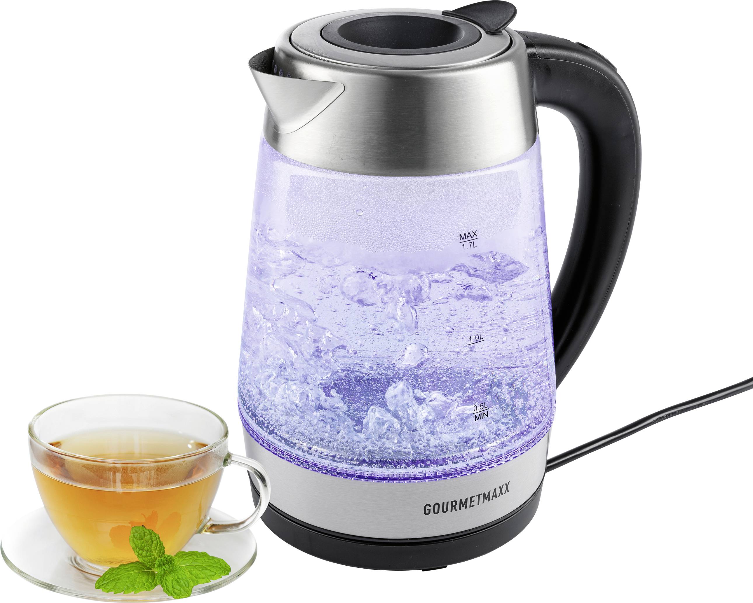 Ein leuchtender elektrischer Wasserkocher mit kochendem Wasser und transparentem Behälter, in dem Blasen zu sehen sind, steht neben einer Glastasse Tee, die mit Minzblättern garniert ist.