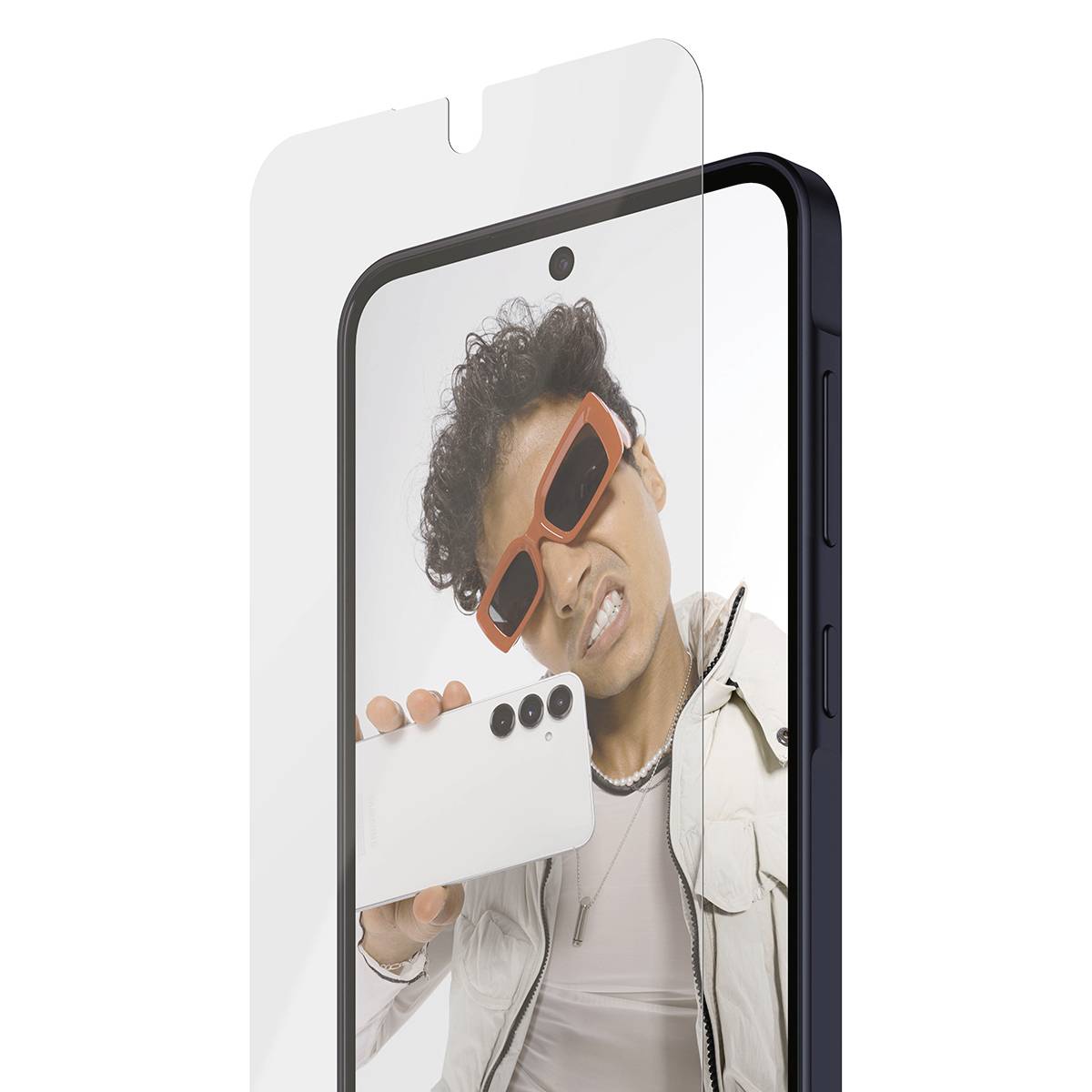 Eine Person mit orangefarbener Sonnenbrille posiert für ein Selfie mit einem Smartphone hinter einer transparenten Displayschutzfolie auf einem Telefonanzeige.