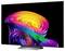Ein Flachbildfernseher, der eine farbenfrohe abstrakte Regenbogenspirale auf schwarzem Hintergrund anzeigt, dargestellt auf seinem Ständer.