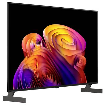 Flacher Fernseher zeigt bunte abstrakte Wirbel auf schwarzem Bildschirm, dargestellt auf Standfuß vor weißem Hintergrund.
