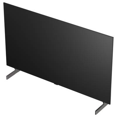 Ein schwarzer Flachbildfernseher in Dreiviertelsicht auf zwei Ständerbeinen vor weißem Hintergrund.