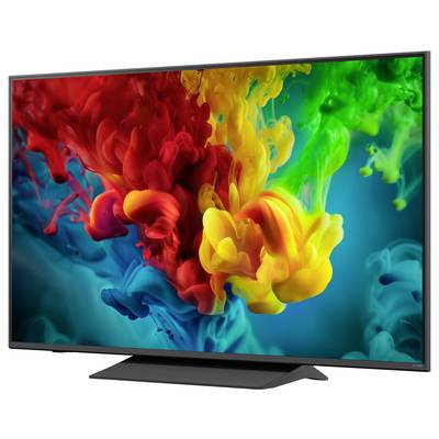 Flachbildfernseher, der einen lebendigen abstrakten Farbausbruch aus roten, gelben, grünen und blauen tintenähnlichen Farbwolken auf dunklem Hintergrund zeigt.