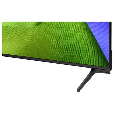 Nahaufnahme eines Flachbildfernsehers oder Monitors auf einem Ständer, auf dem eine grüne und blaue abstrakte Anzeige zu sehen ist.