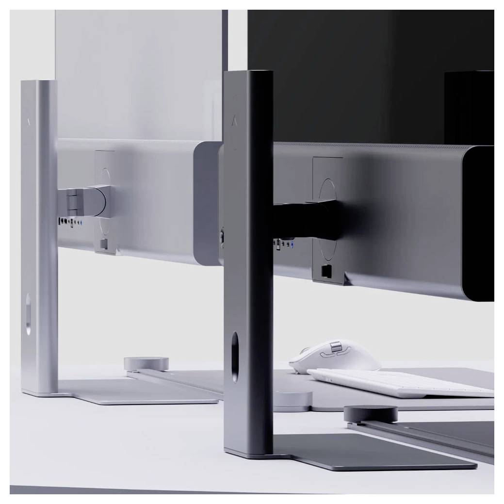 Zwei Desktop-Monitore von hinten auf eleganten Metallständern gezeigt, mit einer weißen Maus und Tastatur auf einem sauberen Schreibtisch.