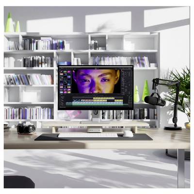 Moderner Bearbeitungsschreibtisch mit einem Monitor, auf dem Videobearbeitungssoftware und ein Nahaufnahmebild eines Gesichts in der Zeitleiste angezeigt werden, sowie eine Kamera und ein Mikrofon in einem hellen Studio-Büro.