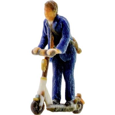 Kleine Figur einer Person in einem blauen Mantel und Hut, die auf einem Tretroller fährt, in der Seitenansicht zu sehen.