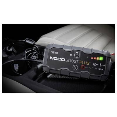 NOCO Boost Plus GB40 tragbarer Starthilfegerät mit beleuchteten Stromanzeigen ruht auf einem Autositz, mit angeschlossenen Kabeln in der Nähe.