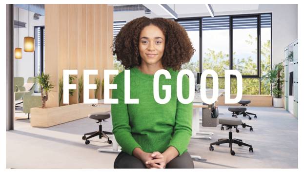 Lächelnde Frau in einem modernen Büro mit den Worten „FEEL GOOD" in der Mitte überlagert.