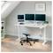 Heimarbeitszimmer mit Stehschreibtisch, Dual-Monitor-Setup, Laptop, Hocker, Tastatur, Maus und kleiner Pflanze in einem hellen Dachzimmer.