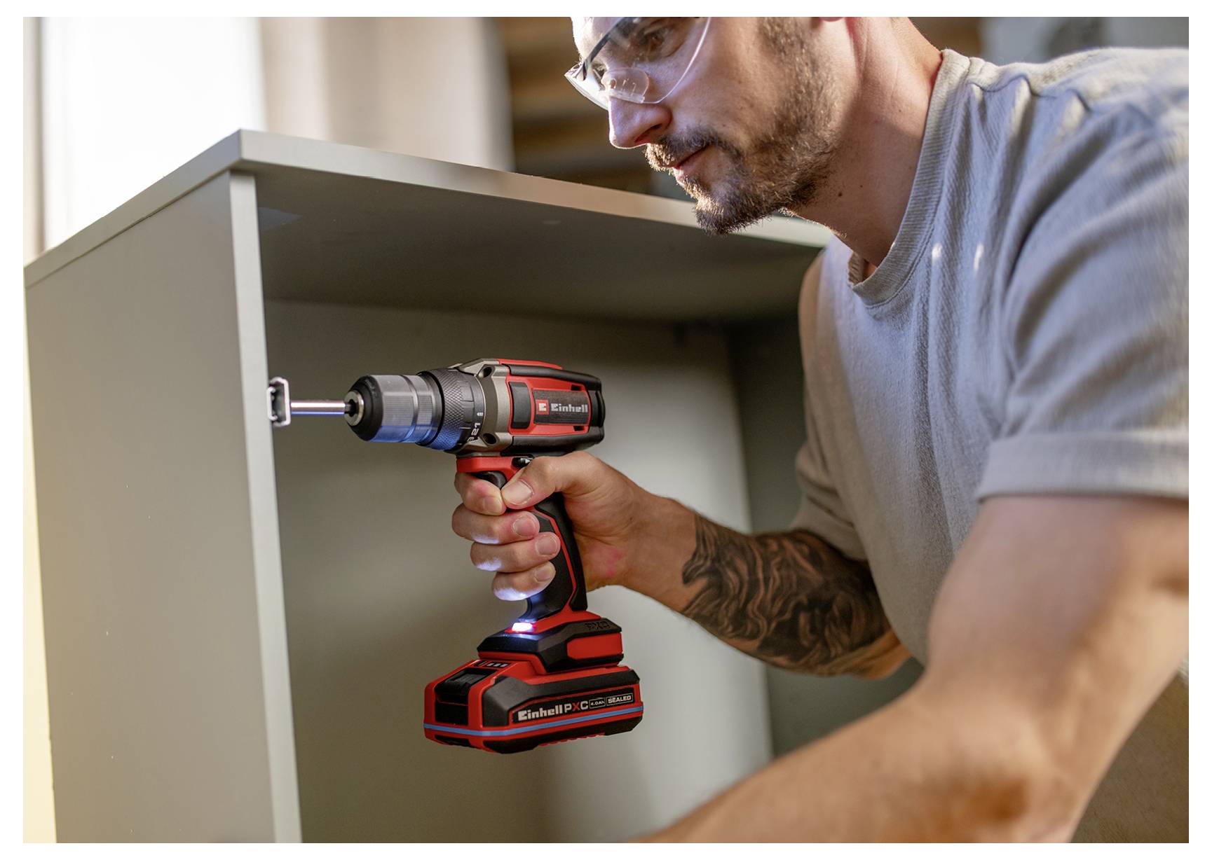 Ein Mann verwendet einen kabellosen Bohrer, um einen Schrank zu montieren oder zu installieren.