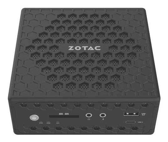 Kompakter schwarzer Zotac Mini-PC mit Zotac-Logo auf der Oberseite, Sechskant-Lüftungsmuster und Indikatoren für Stromversorgung, Audio, USB und Anschlüsse auf der Vorderseite.