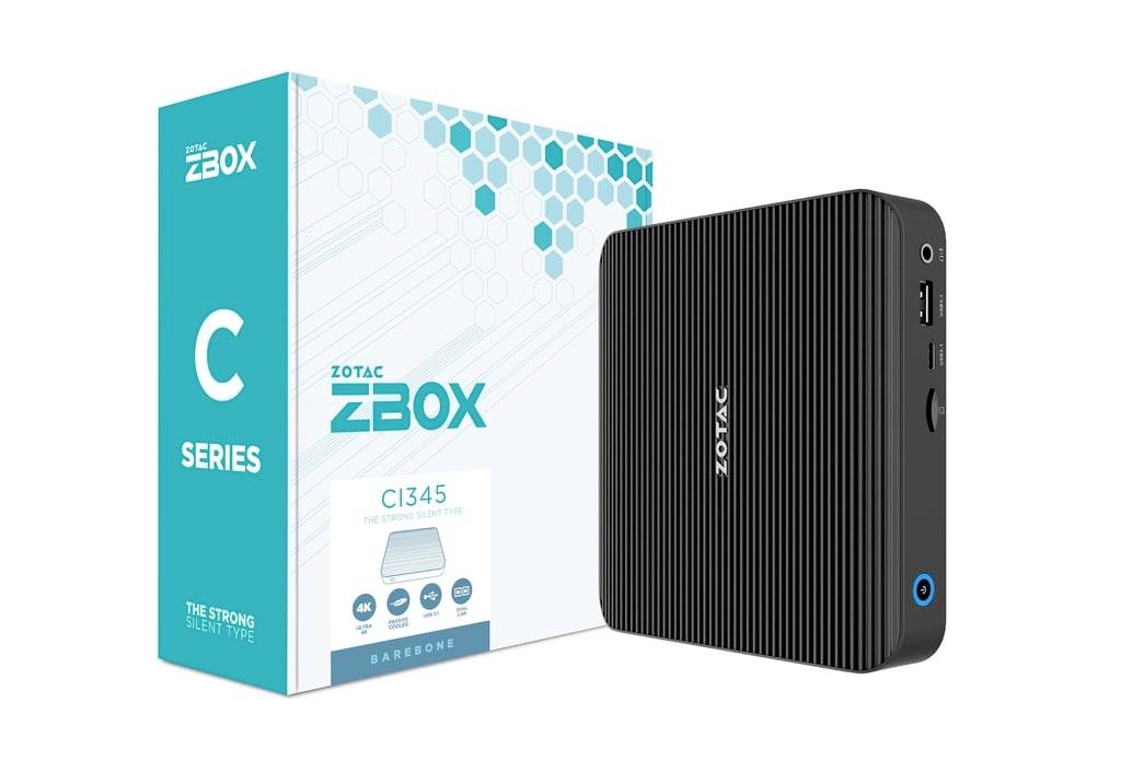 Zotac ZBOX C Series CI345 Mini-PC neben seiner Einzelhandelsverpackung gezeigt, ein kompakter schwarzer Desktop-Computer mit USB- und Audio-Anschlüssen auf der Vorderseite.