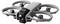 Grauer Quadcopter-Drohne mit vier Propellerschutzvorrichtungen und einer frontal montierten Kamera, perspektivisch auf weißem Hintergrund dargestellt.