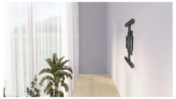 Leeres minimalistisches Zimmer mit einem großen Fenster und transparenten Vorhängen, Topfpflanzen am Fenster und einer wandmontierten Fernseh-Halterung an der rechten Wand.