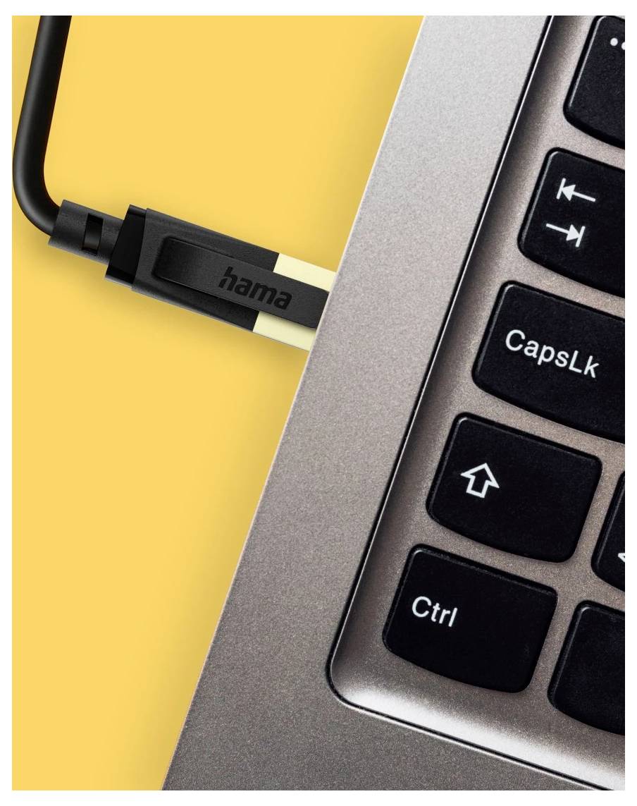 Nahaufnahme eines USB-Kabels, das in die Seite eines Laptops neben der Tastatur eingesteckt ist, mit Tasten mit den Beschriftungen "CapsLk" und "Ctrl".