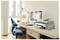 Helles Homeoffice mit blauem Stuhl, Schreibtisch, Computer, Drucker, Lampe und Zubehör neben einem Fenster.