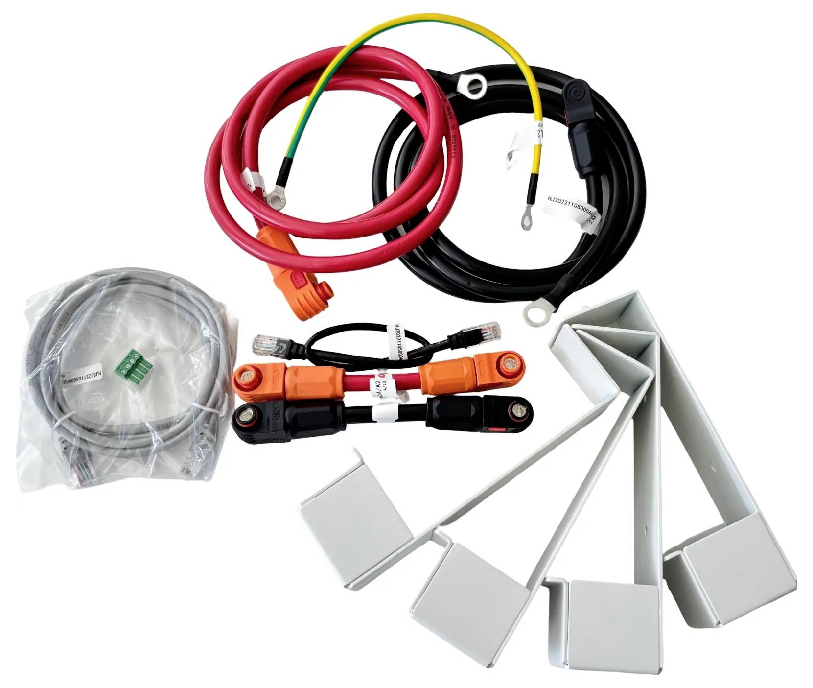 Verschiedene Elektrokabel und Stecker, einschließlich roter und schwarzer Batteriekabel, ein aufgerolltes graues Kabel und mehrere graue Kabelbaum-Teile auf weißem Hintergrund.