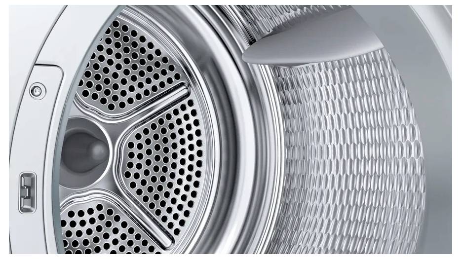 Nahaufnahme einer Frontlader-Trockner-Trommel mit perforiertem Metallinneren und Türverriegelung auf der linken Seite.