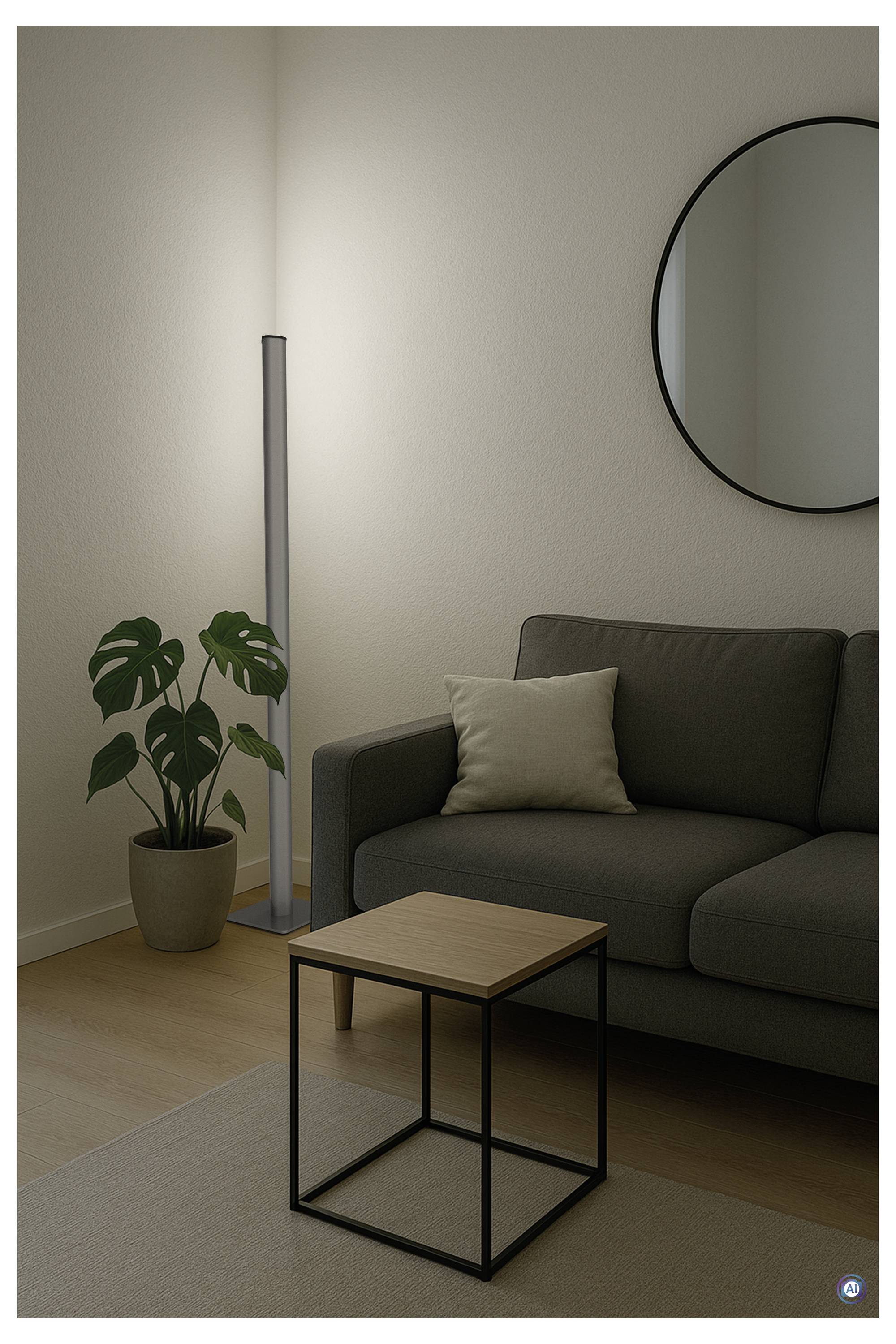 Minimalistisches Wohnzimmer mit grauem Sofa, Pflanze, Stehleuchte, rundem Spiegel und kleinem Couchtisch auf einem Teppich.