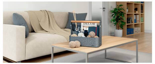 Wohnzimmer mit einem beigen Sofa, einem Holz-Couchtisch und einem dekorativen Korb mit der Aufschrift „DECOR", der Wollknäuel und Handwerkswerkzeuge enthält.