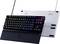 Mechanische Gaming-Tastatur auf schwarzer Laptop-ähnlicher Basis mit regenbogenfarbig beleuchteten Tasten und einer leuchtenden rosa Kontrolldrehscheibe auf einem weißen Ständer dahinter.