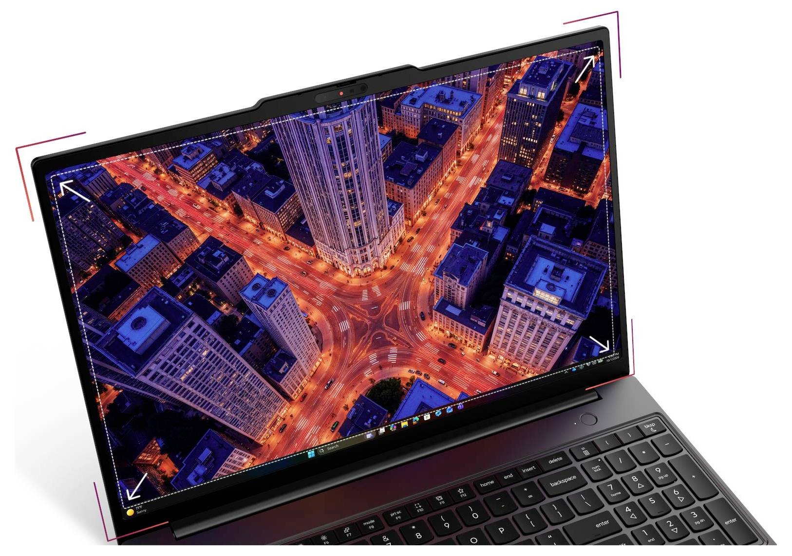 Geneigter Laptop mit großem Bildschirm, der eine Luftaufnahme einer Stadtkreuzung bei Nacht zeigt, mit leuchtenden orangefarbenen Lichtschweifen von Ampeln zwischen hohen Gebäuden.