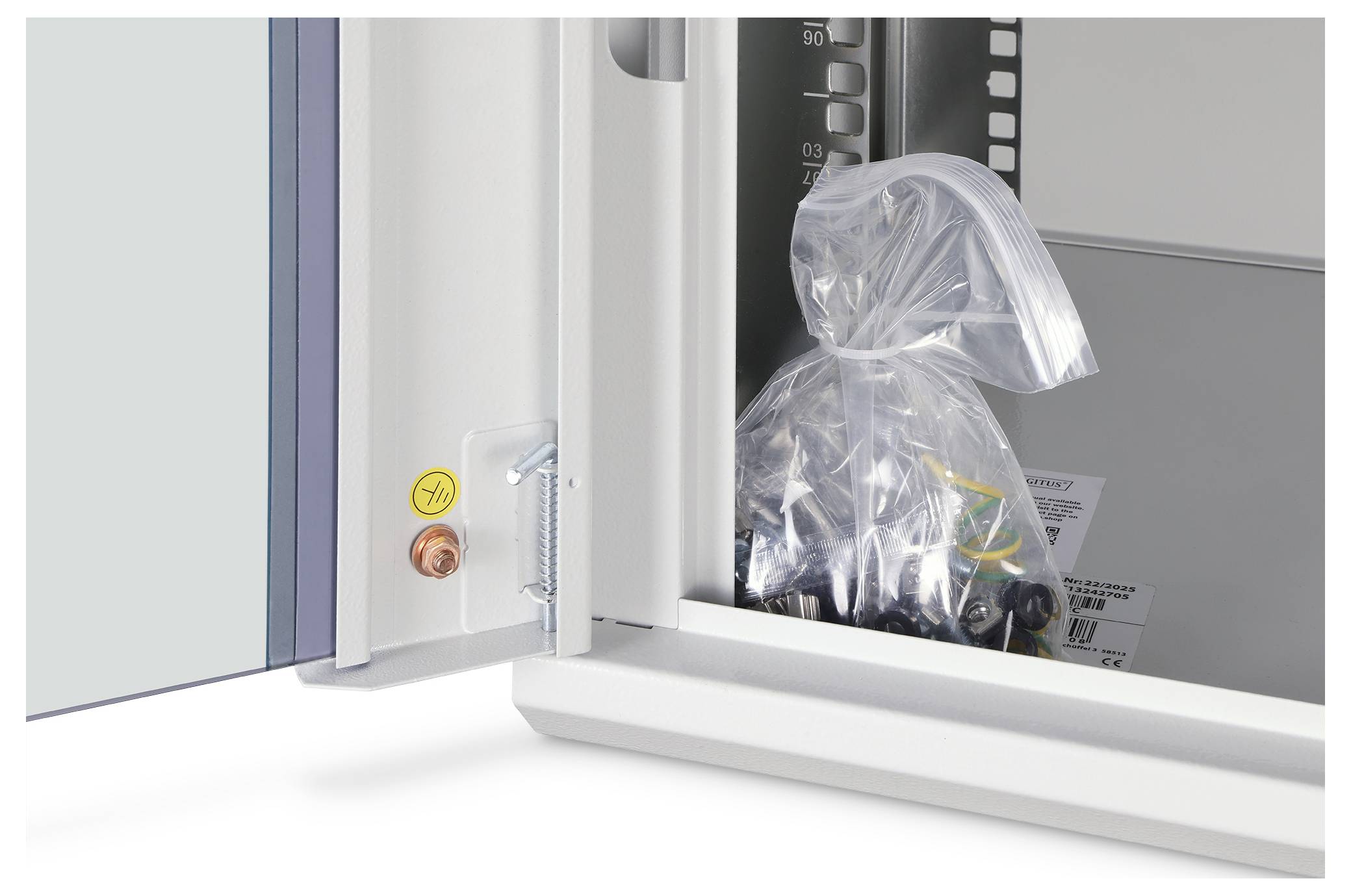 Plastiktüte mit Ausrüstung, die in einem offenen weißen Elektroschrankgestellt ist, mit sichtbaren Stromreglern auf der Tür
